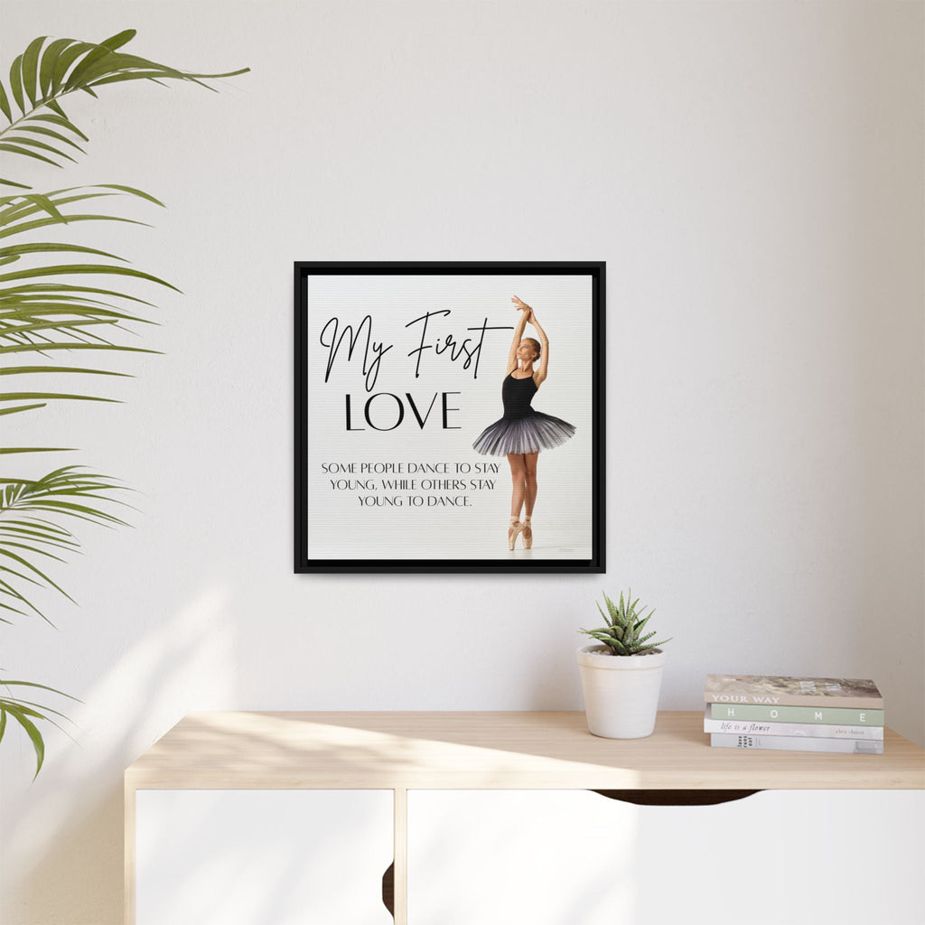 Framed artwork of a ballerina with text on a wall above a desk with plants and books.