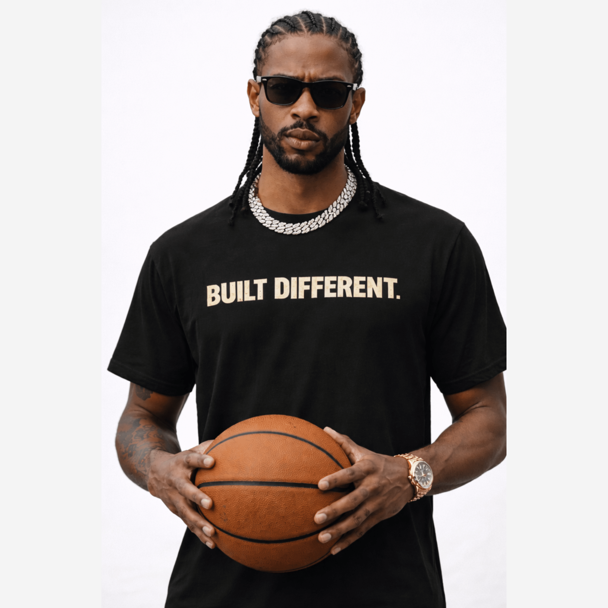 Male model wearing a black 'Built Different' t-shirt holding a basketball on a white background