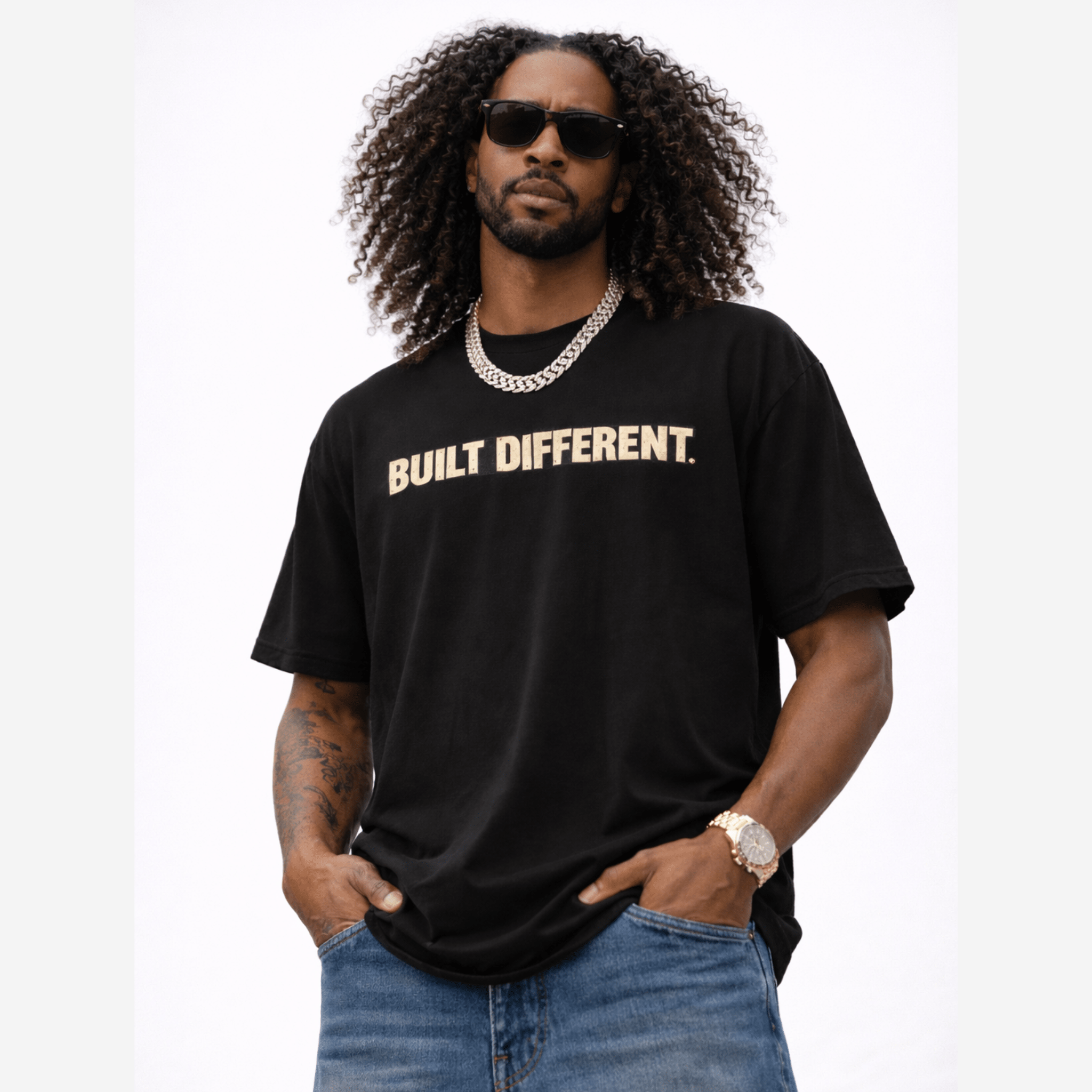 Man posing and wearing a black t-shirt with 'BUILT DIFFERENT' text on a white background