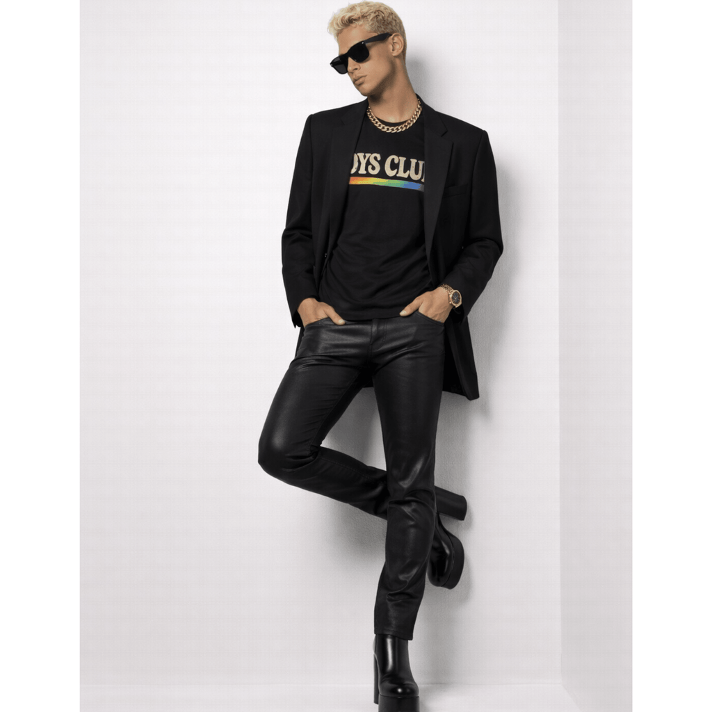 Male model wearing a black suit with a colorful shirt while posing against a white background