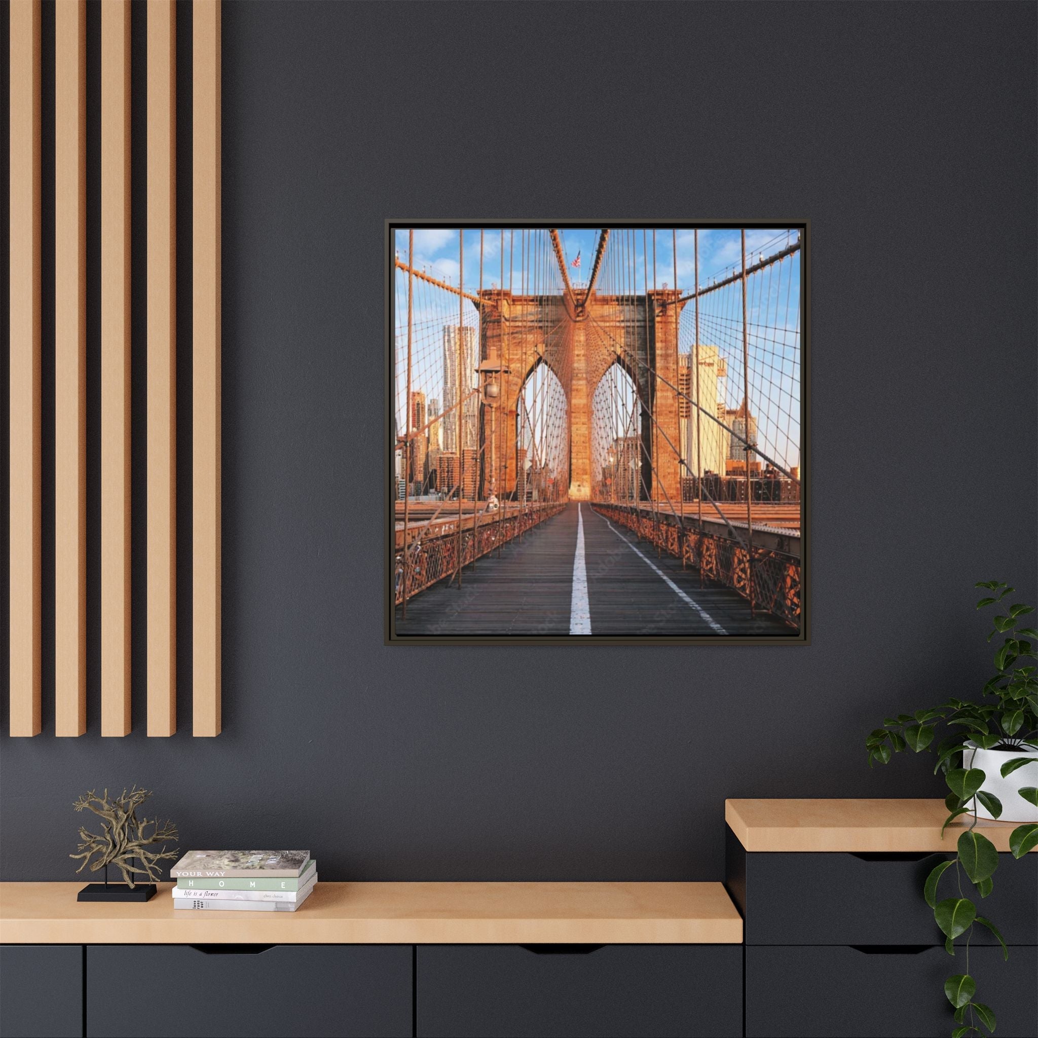 Framed picture of Brooklyn bridge with skyline on a dark wall with wooden shelves below.
