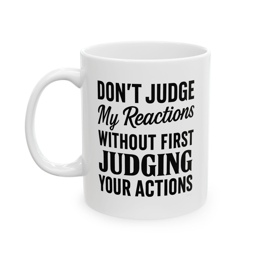 White ceramic mug with quote 'Dont Judge My Reactions' in black text on a white background by Relatable Designs.