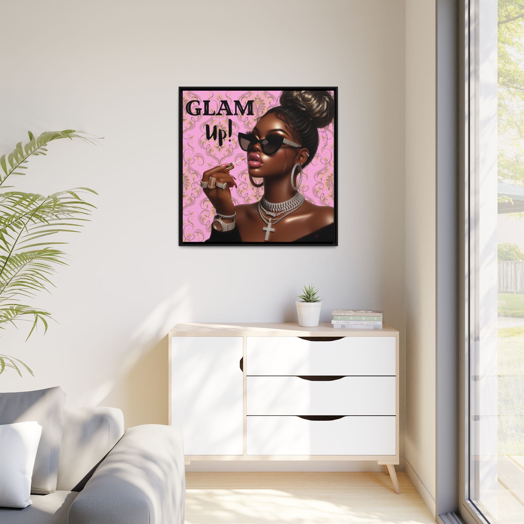 Framed artwork of a woman with 'GLAM UP!' text on a pink background in a modern living room.