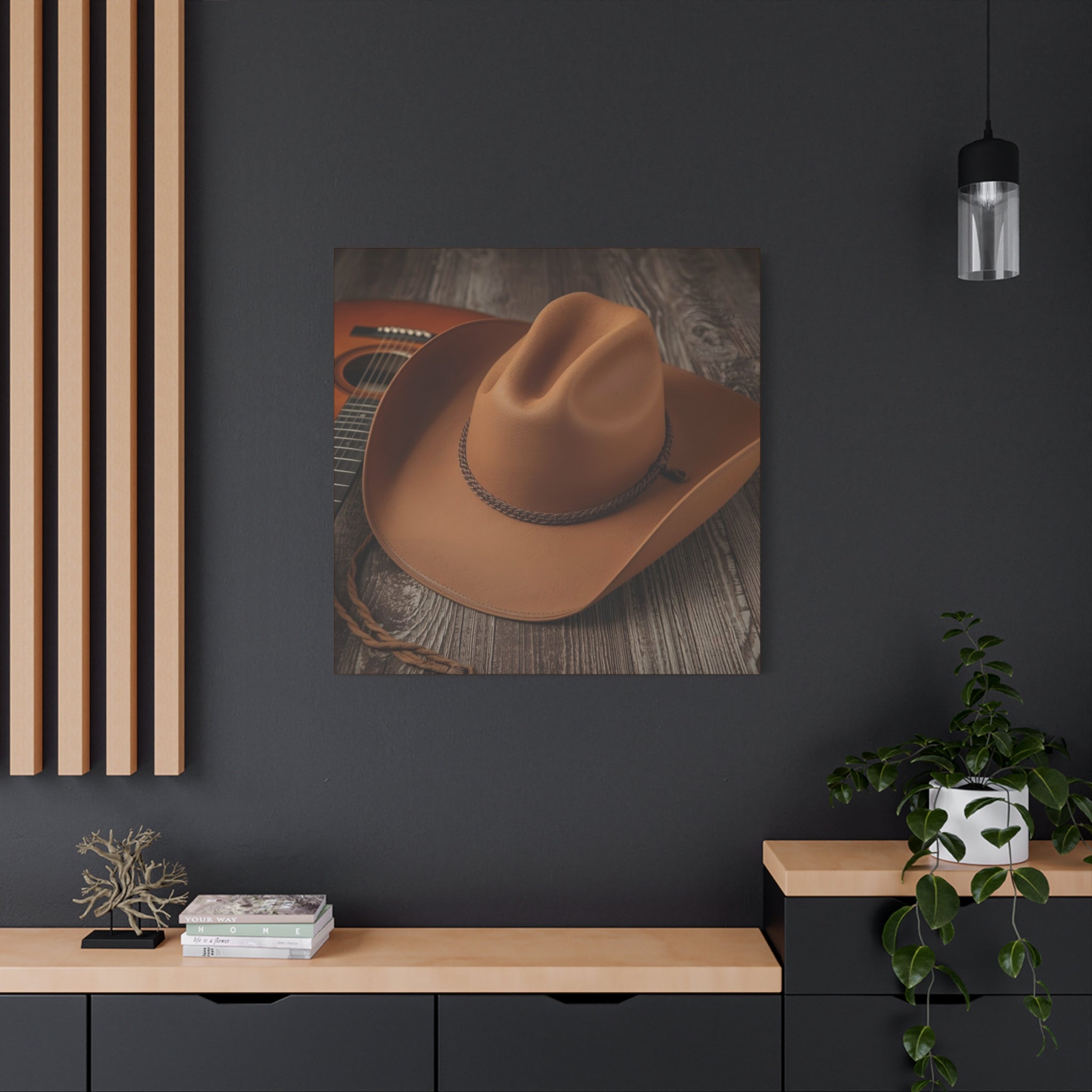 Framed rustic picture of a cowboy hat on a dark wall with a wooden shelf and plant.