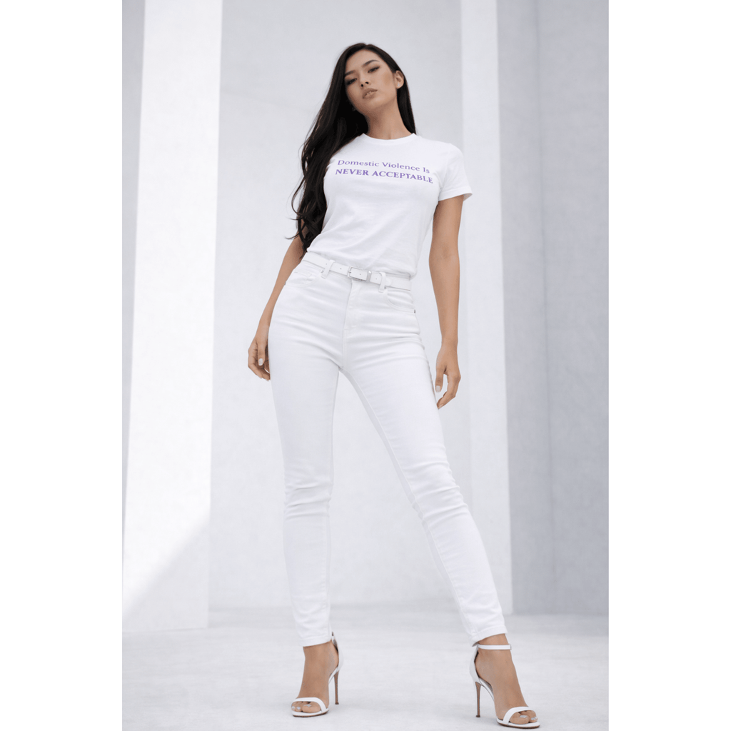 Woman wearing a white t-shirt with text "Domestic Violence Is Never Acceptable" and white pants in a modern pose on a white background by Relatable Designs