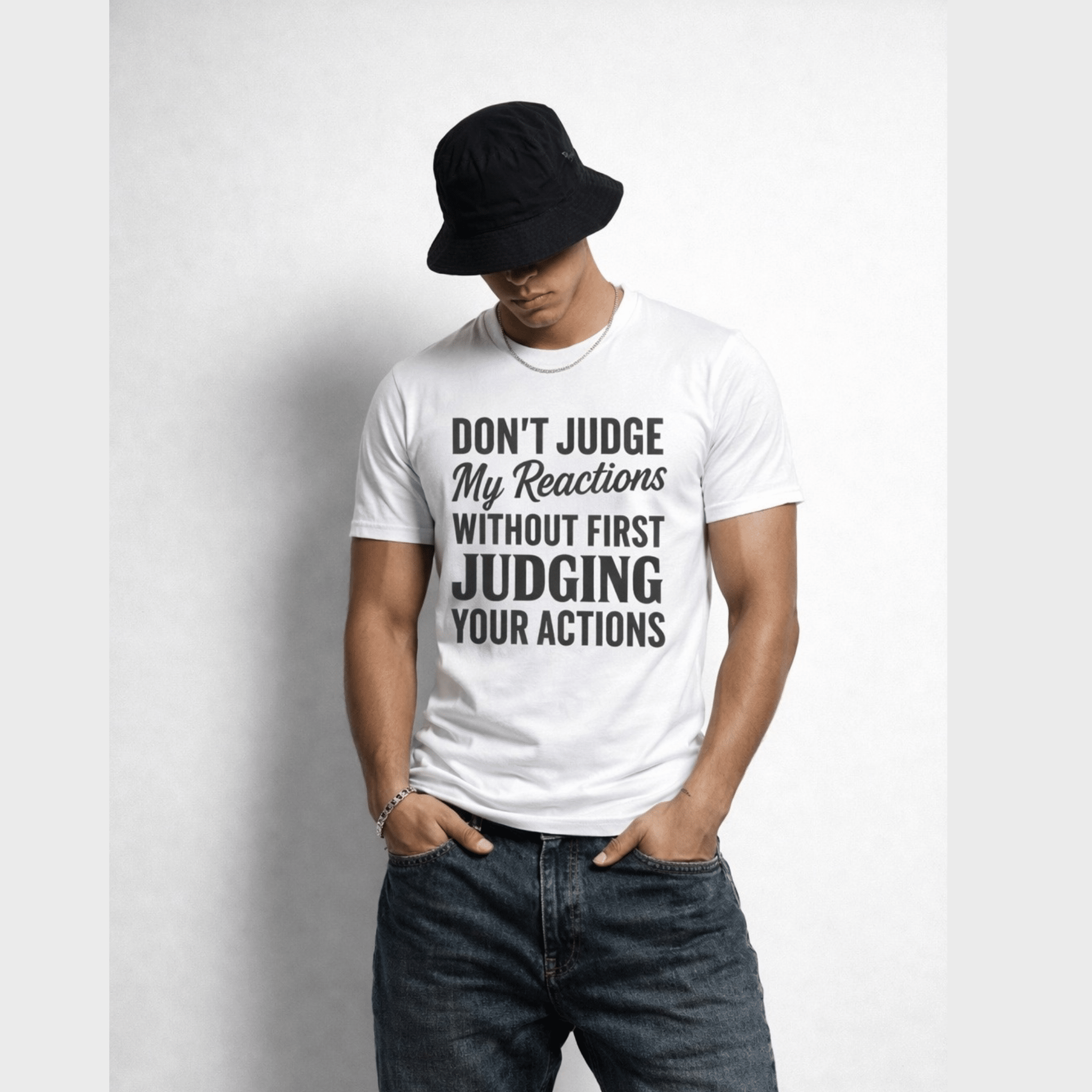 Man wearing a white t-shirt with text ' Don't Judge My Reactions Without First  Judging Your Actions' and a black hat with relaxed streetwear look by Relatable Designs