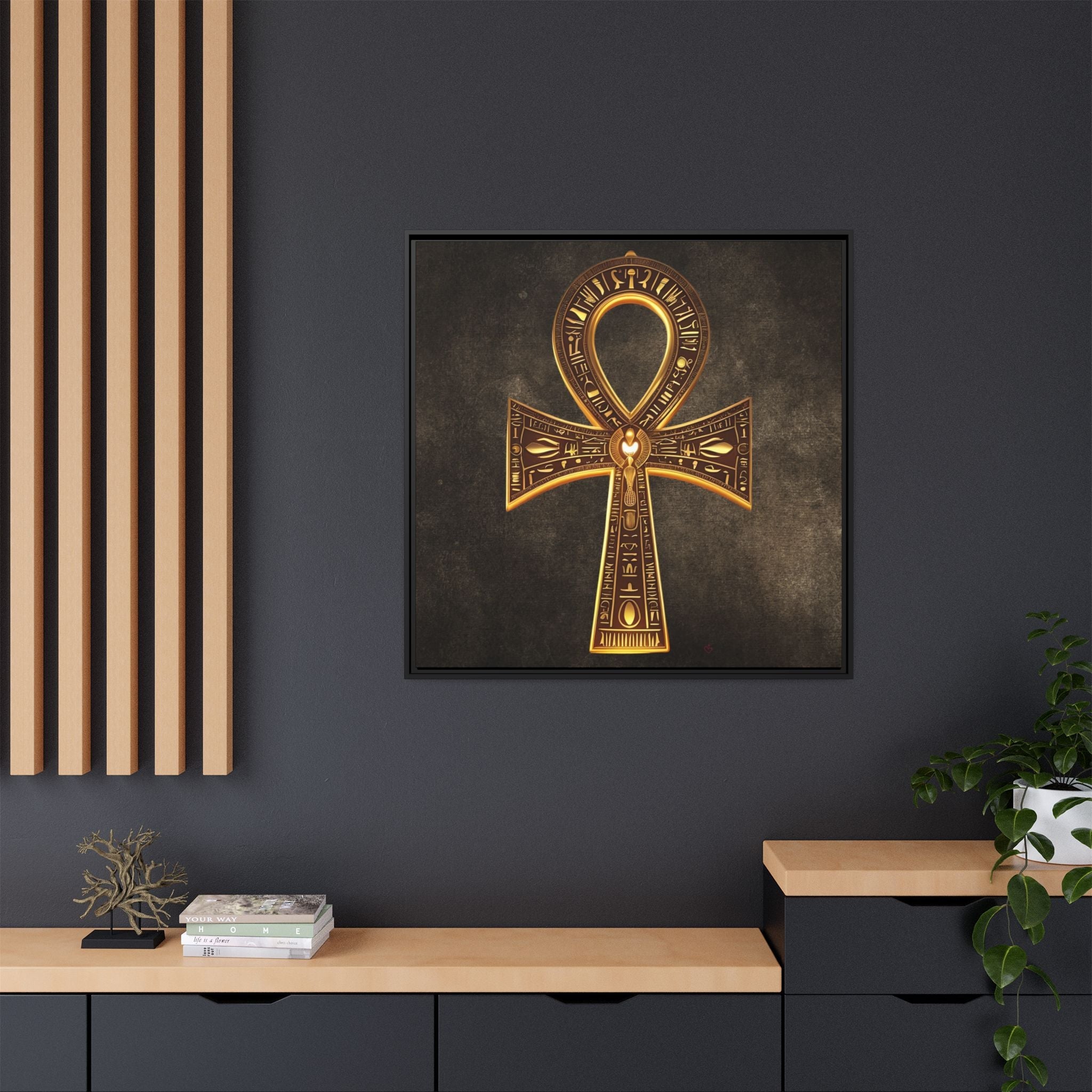 Framed artwork of a gold Ankh symbol on a dark wall with decorative elements.