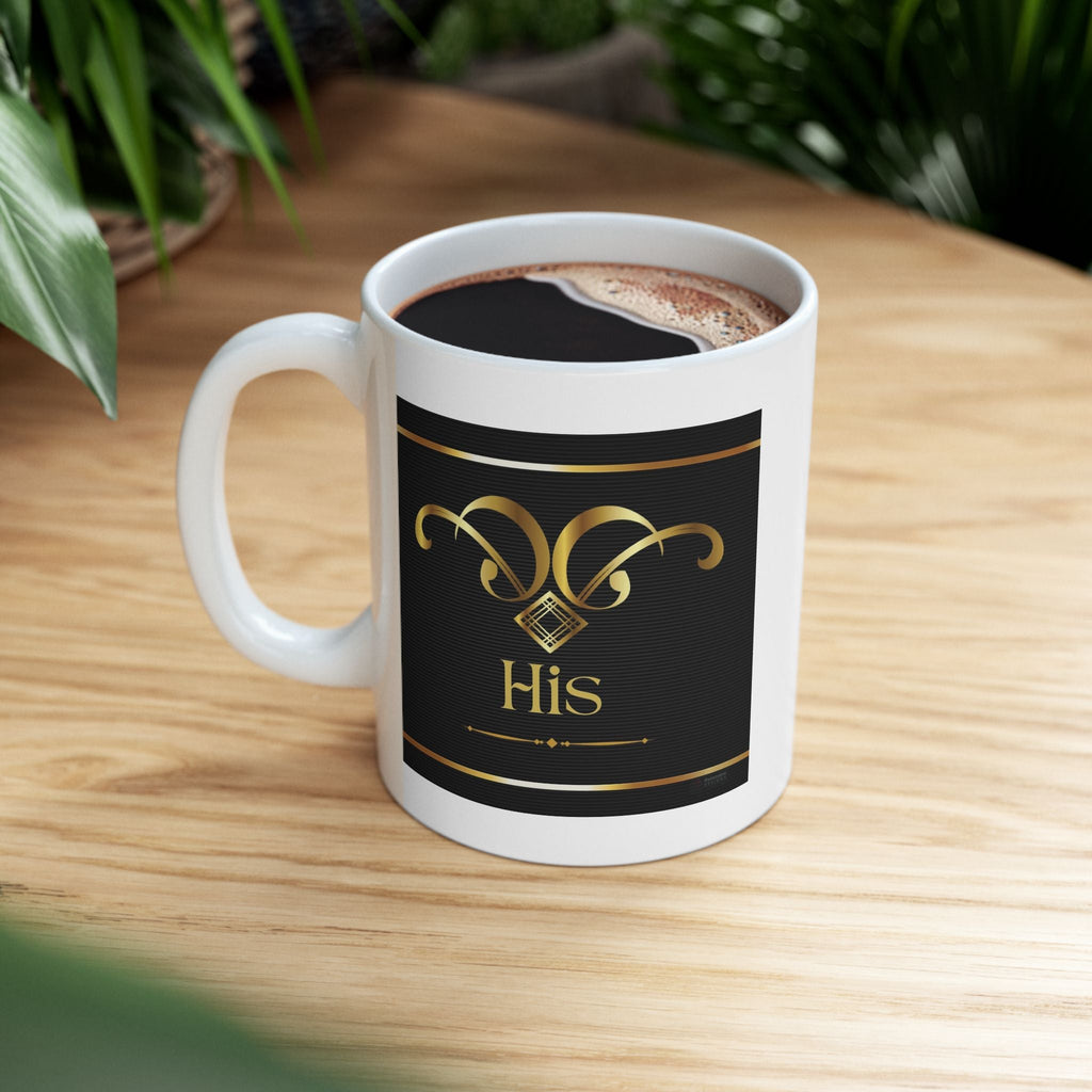 Elegant white coffee mug with black label featuring gold design and 'His' text on a wooden surface.