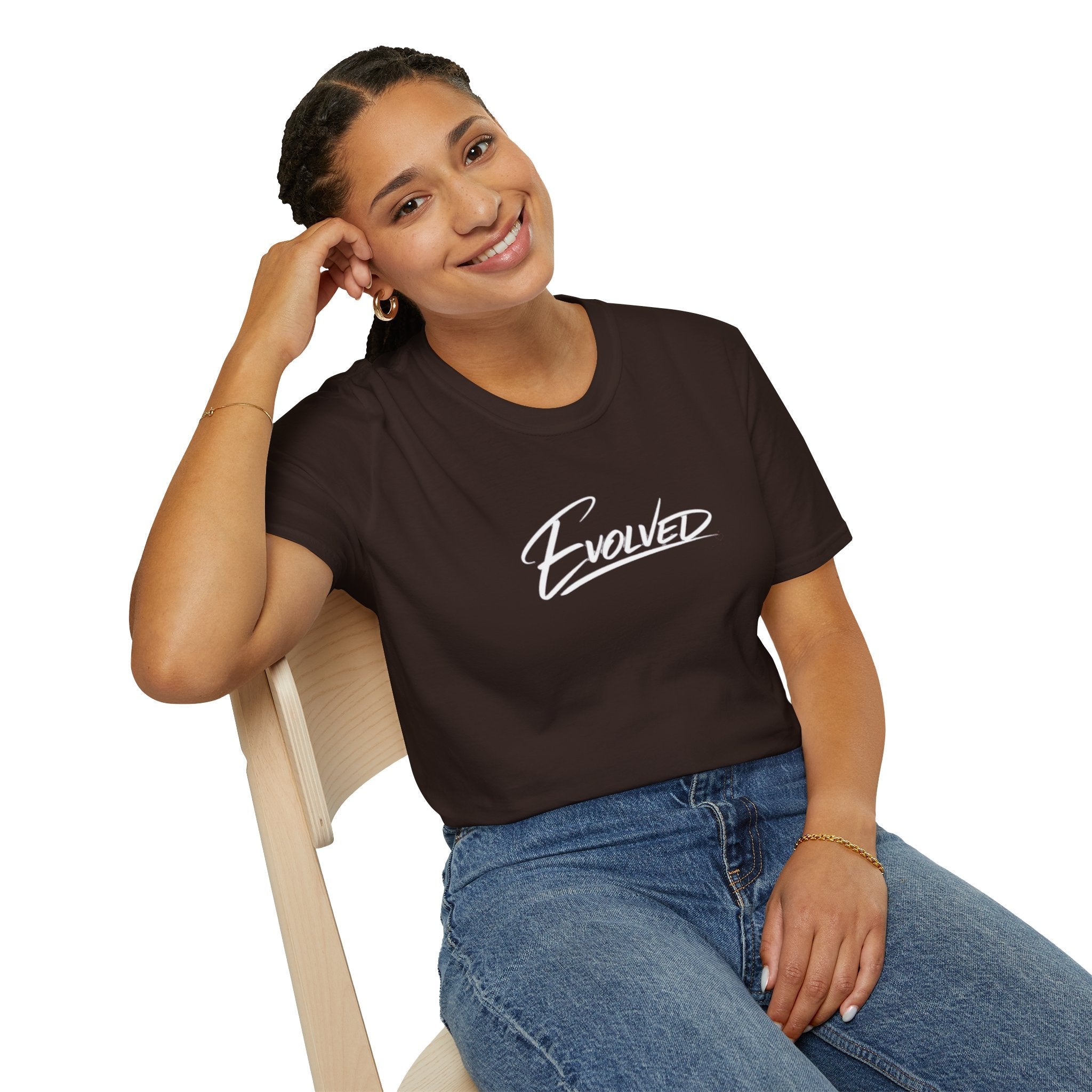 Woman wearing a brown t-shirt with 'Evolved' text, sitting on a chair against a white background
