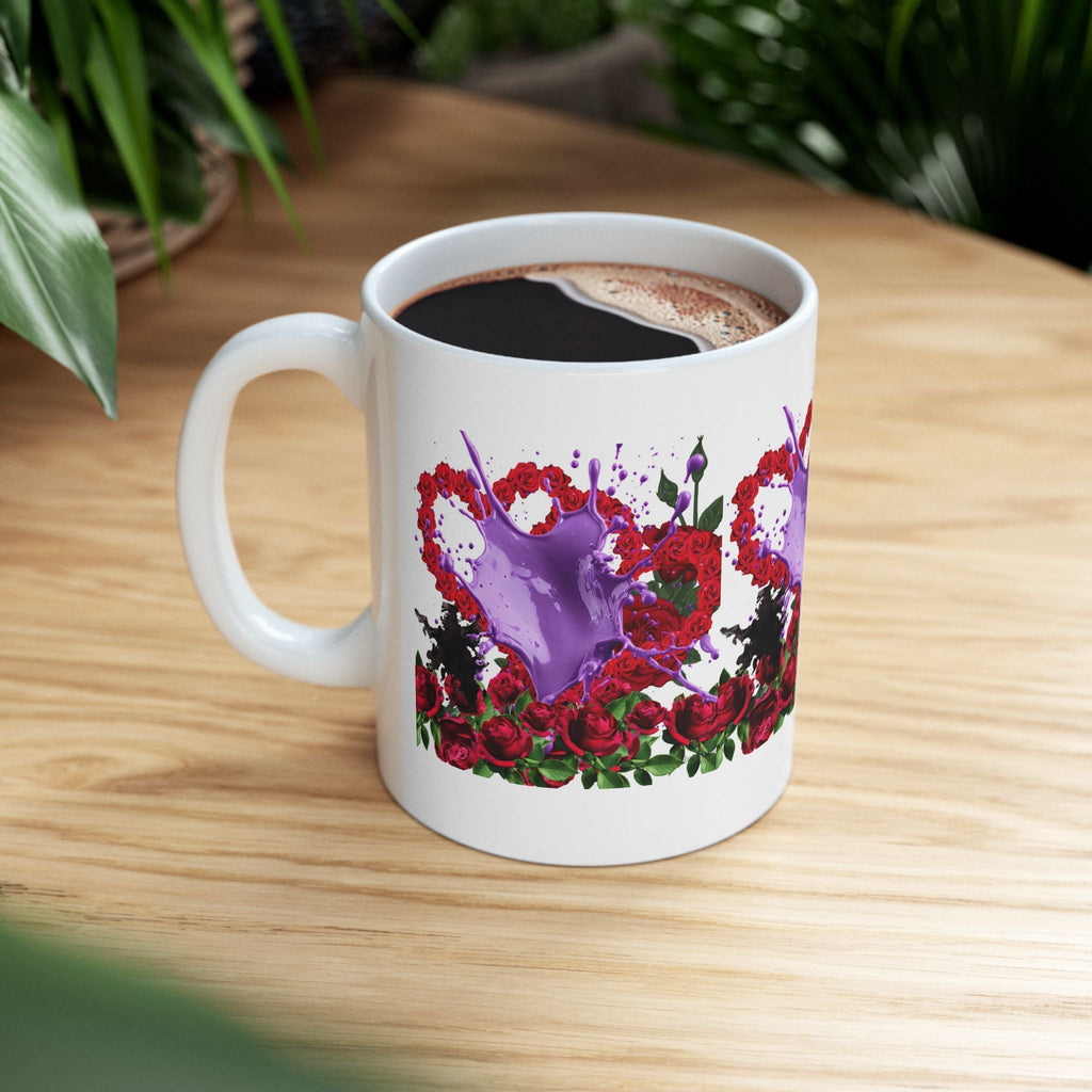 White mug with red floral heart design with purple splash of paint on a wooden table