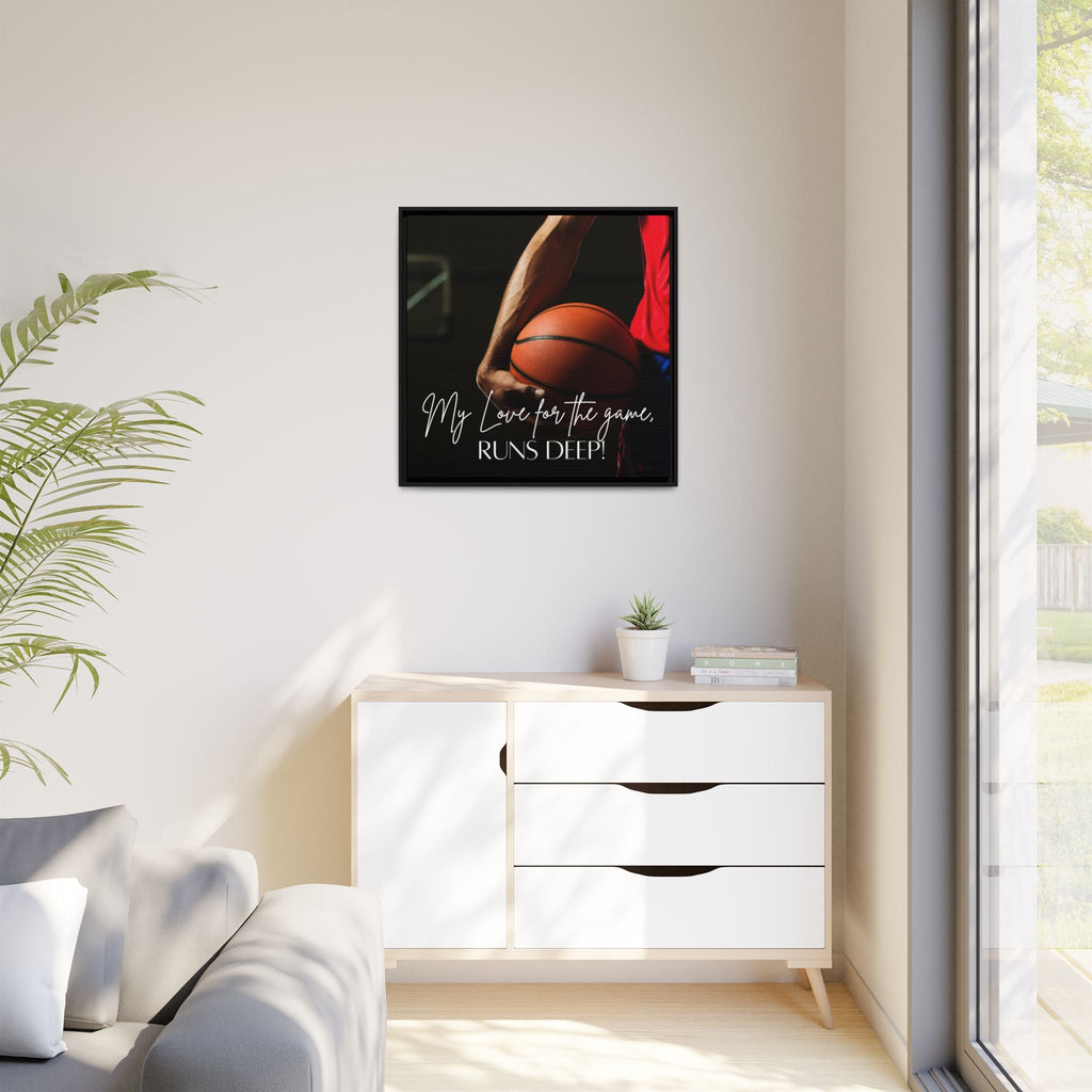 Framed artwork with a basketball theme on a wall above a white cabinet.