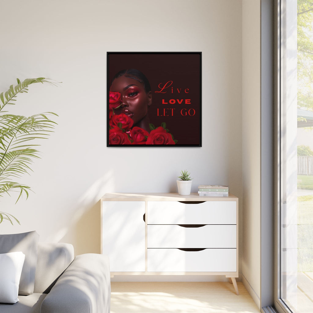 Framed inspirational artwork with a woman's face and roses on a wall above a white cabinet.