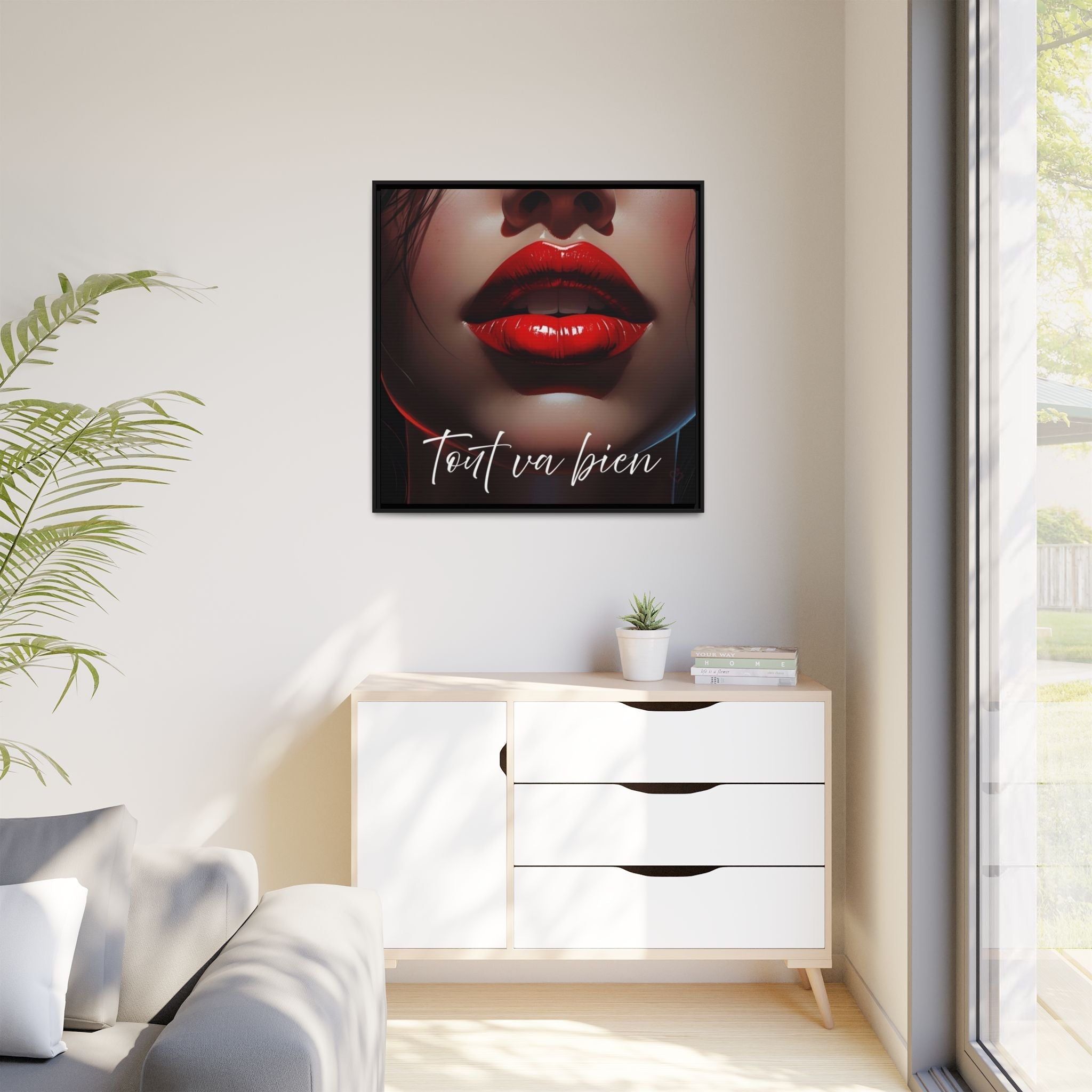 Framed artwork with red lips and text on a wall above a white cabinet.