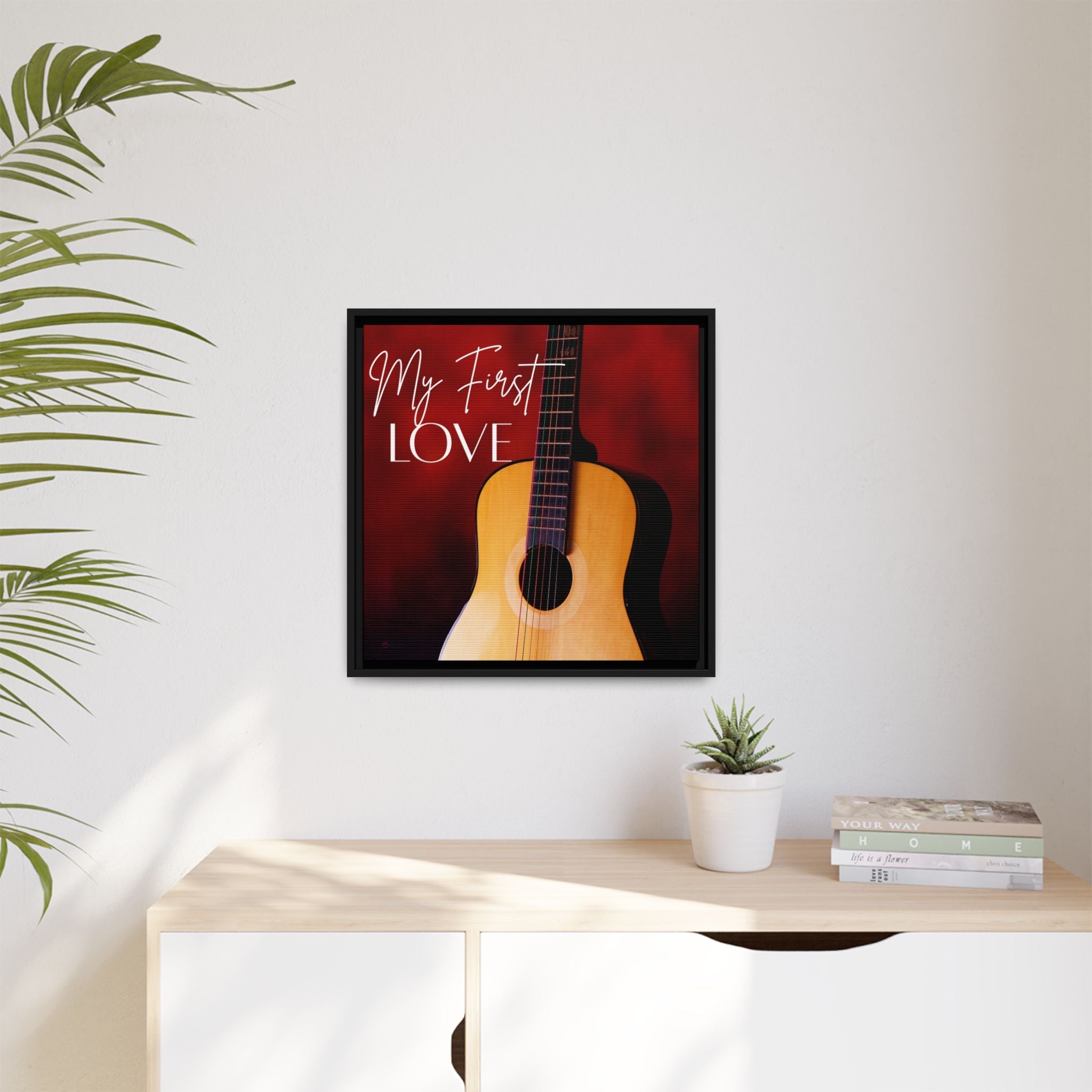 Framed artwork of a guitar with 'My First Love' text on a wall above a desk.