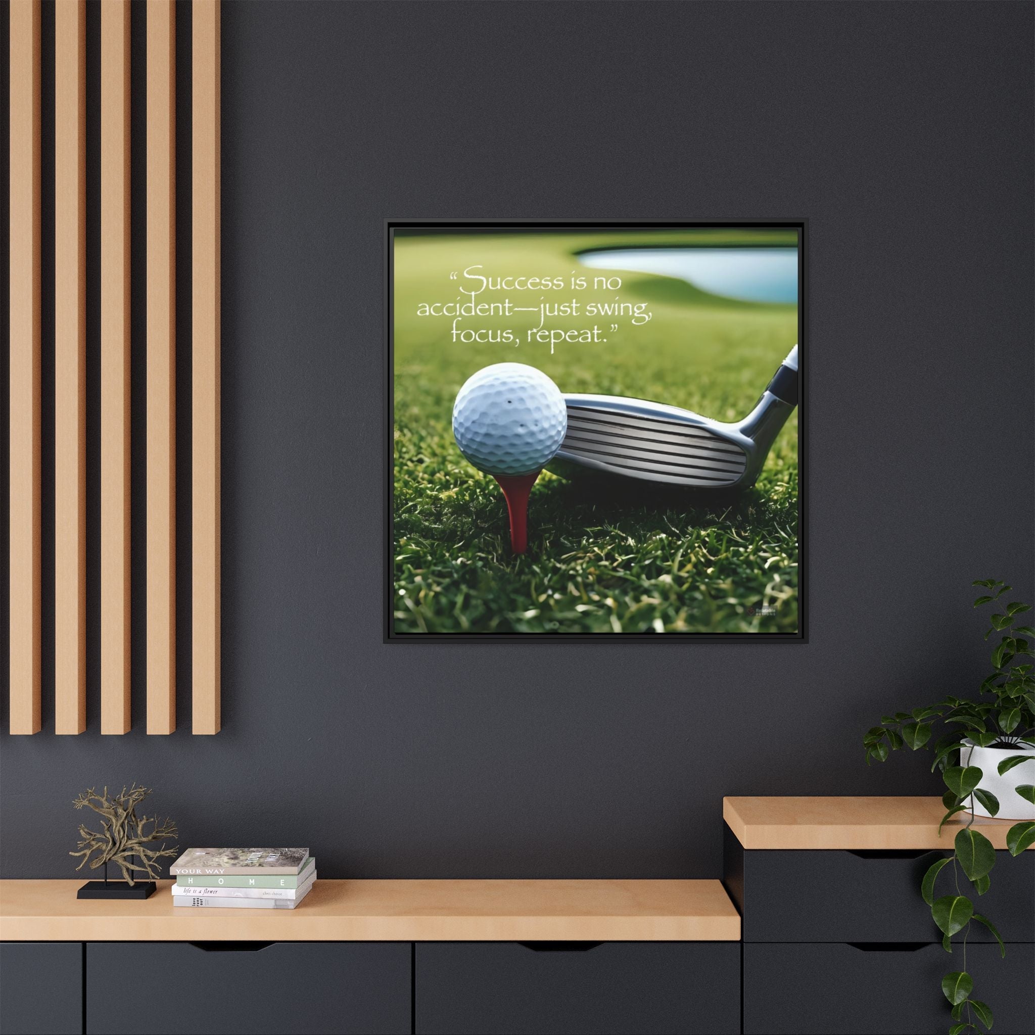 Framed motivation picture of a golf club and ball on grass with quote mounted on a dark wall.