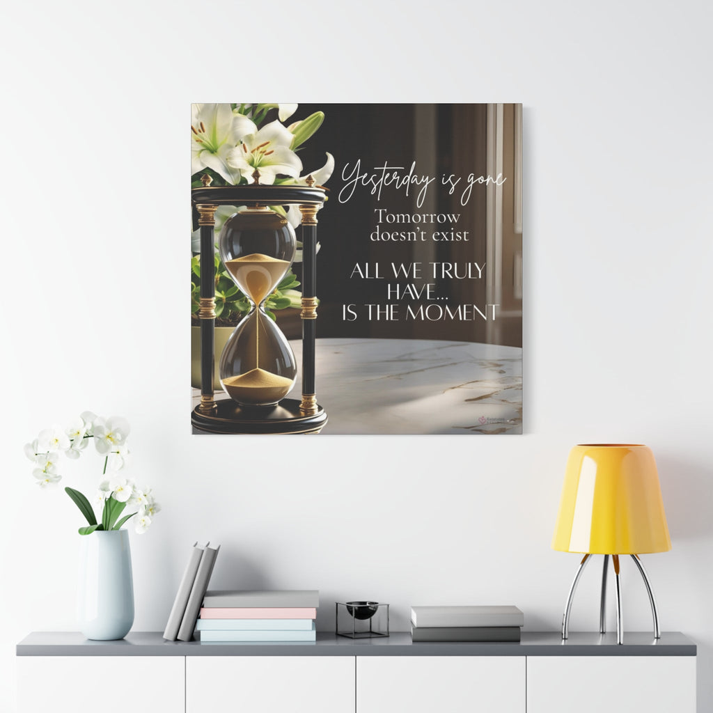 Canvas print with an hourglass and motivational quote on a wall above a table with decor items.