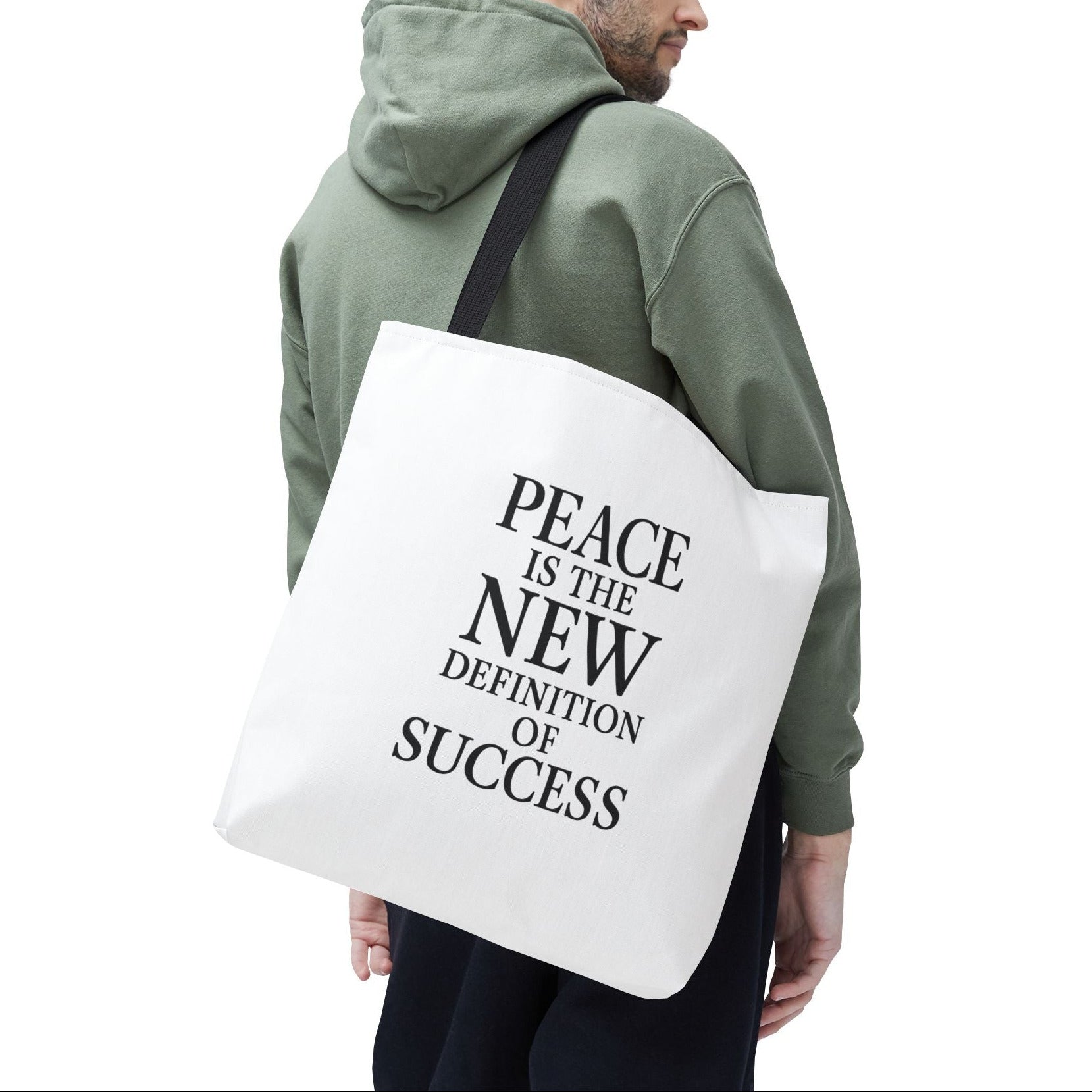 Man carrying a tote bag with 'Peace is the new definition of success' text on a white background