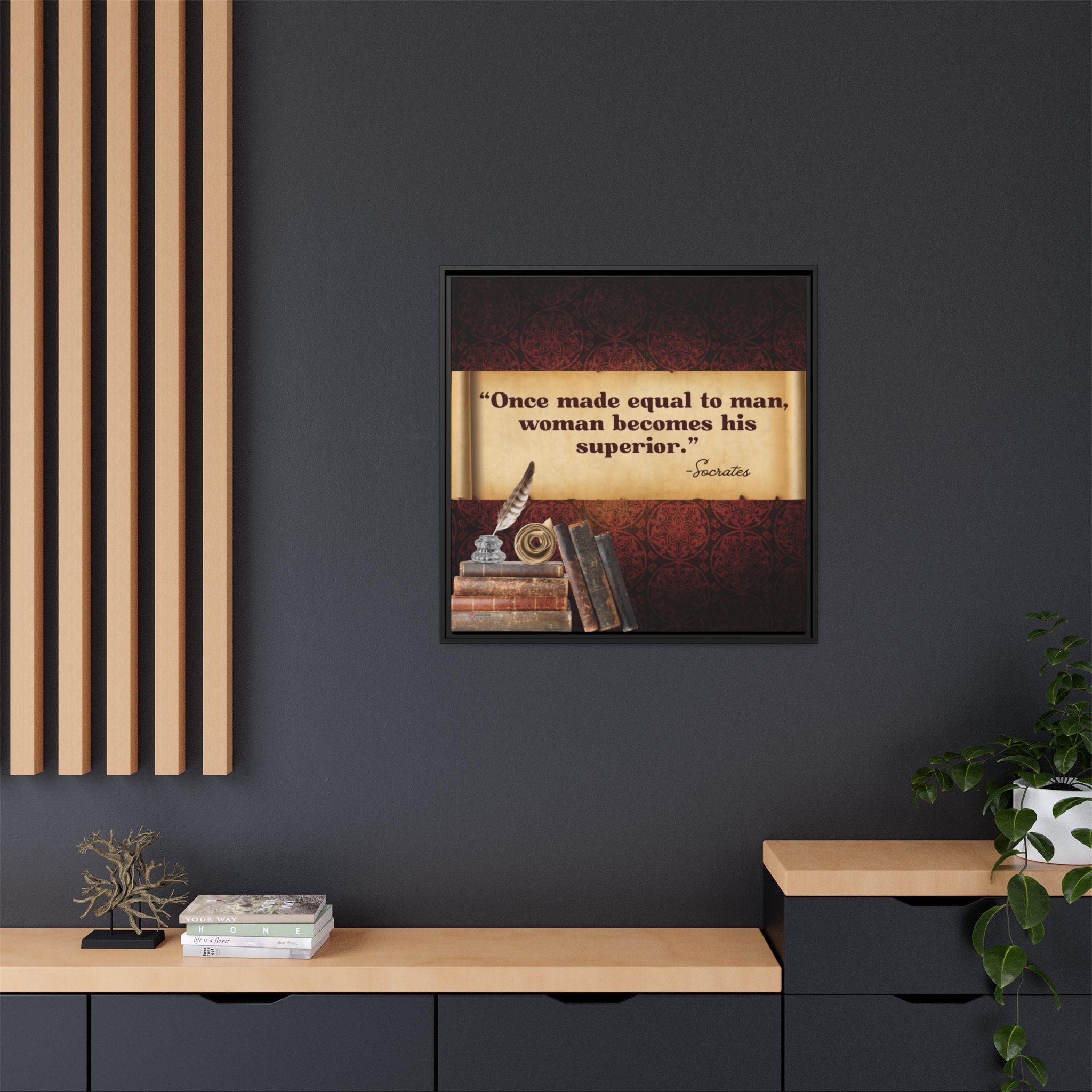 Framed inspirational quote with books and quill pen in inkwell on a dark wall with decorative elements.