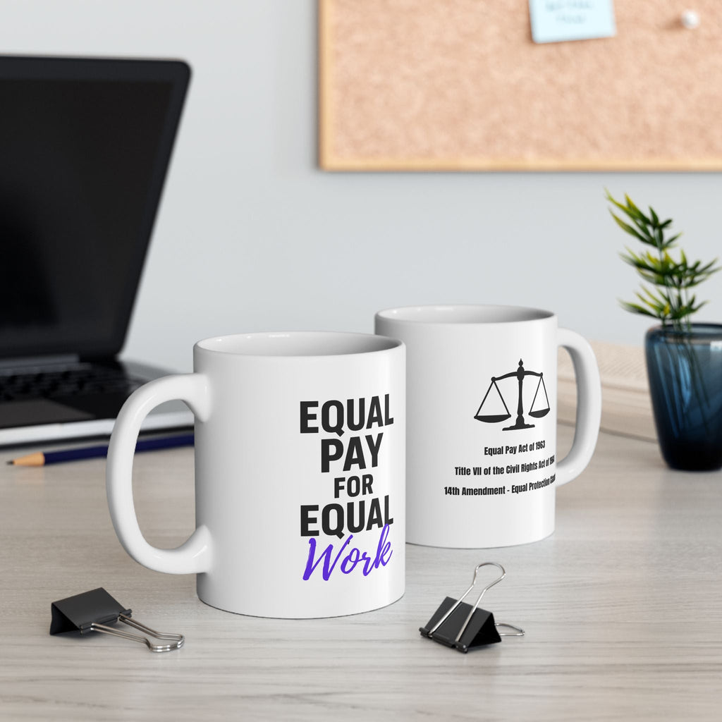 Two mugs on a desk with 'Equal Pay for Equal Work' text and a laptop in the background.