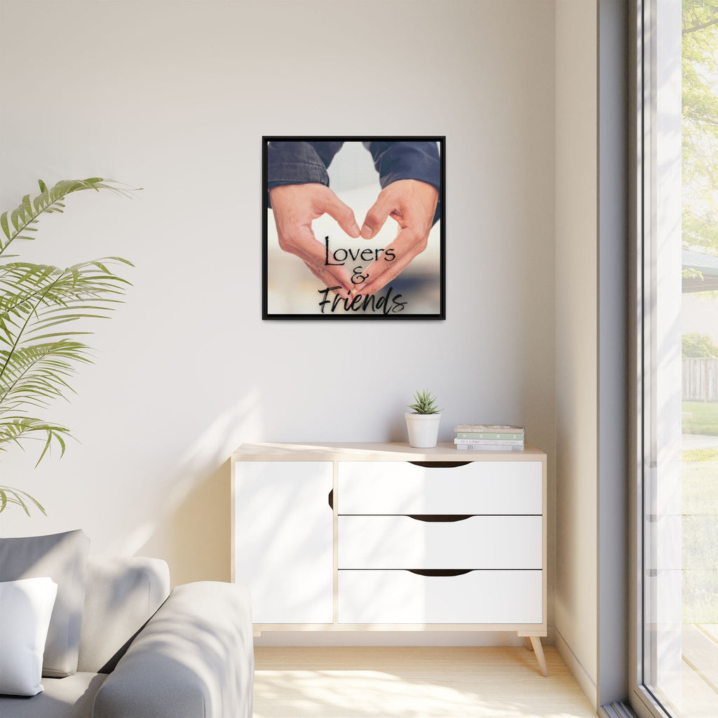 Framed artwork with hands forming a heart shape on a wall above a white cabinet in living room.