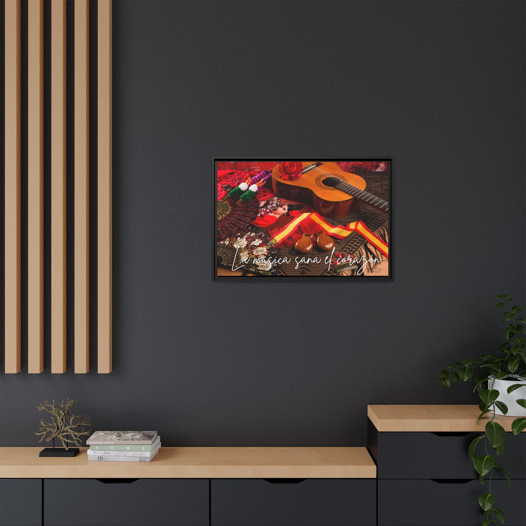 Framed Spanish musical artwork of a guitar and flowers on a dark wall with wooden furniture.