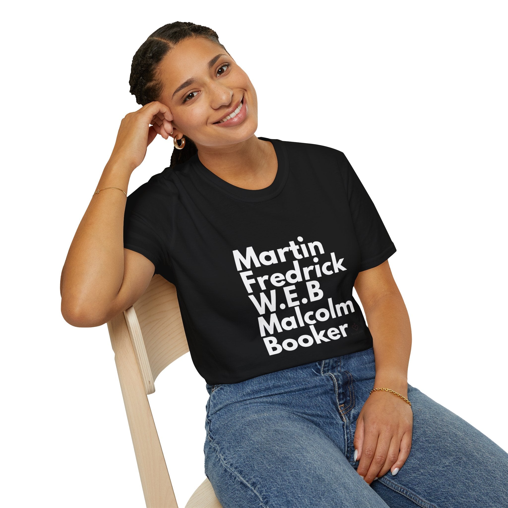 Person wearing a black t-shirt with black leaders in white text sitting on a chair.