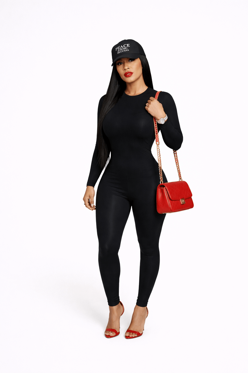 Female model wearing black outfit with red handbag and Peace Is The Success black cap on white background
