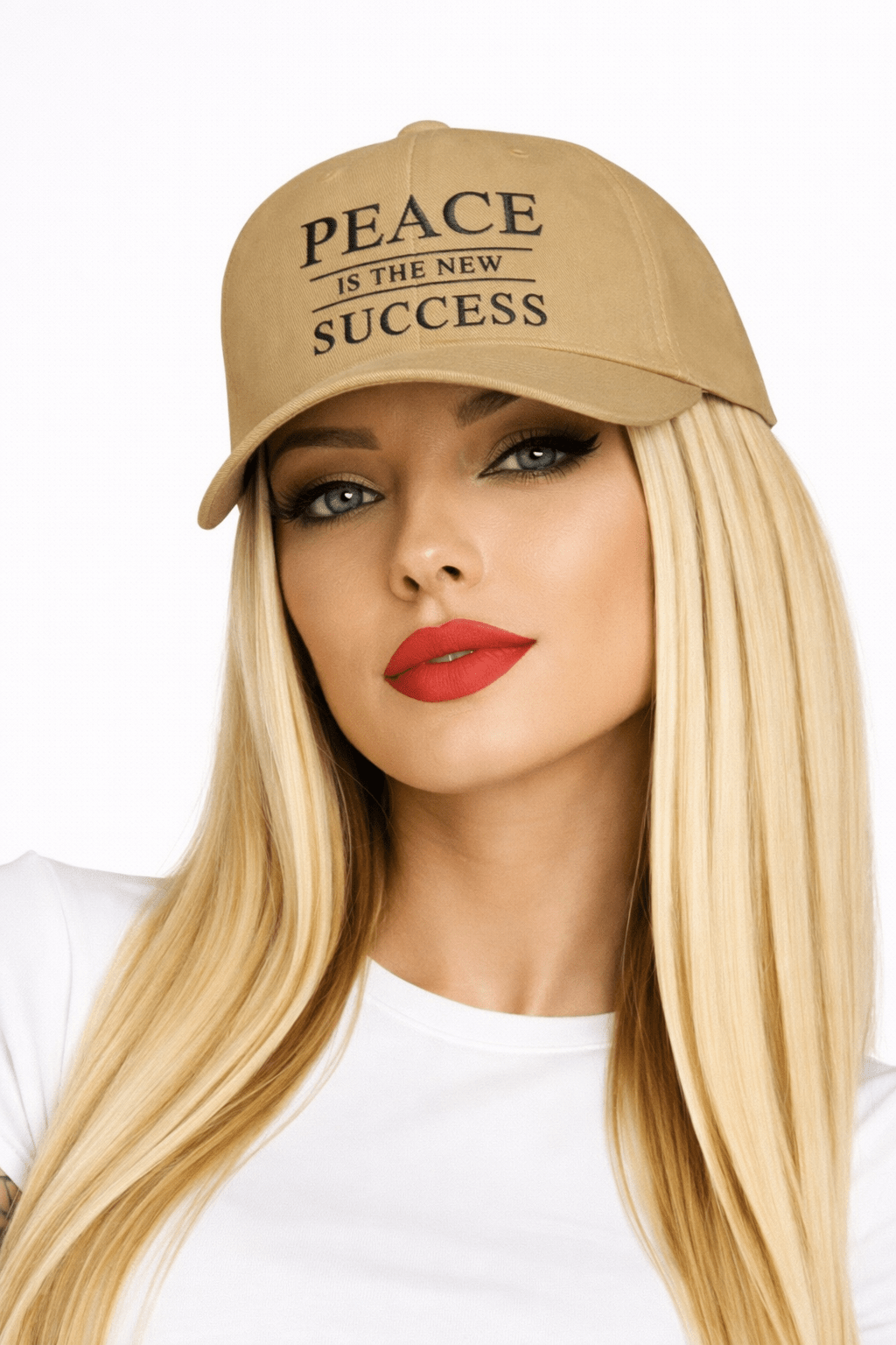 Close-up of model with blonde hair and red lipstick wearing khaki embroidered cap with text Peace Is the New Success  