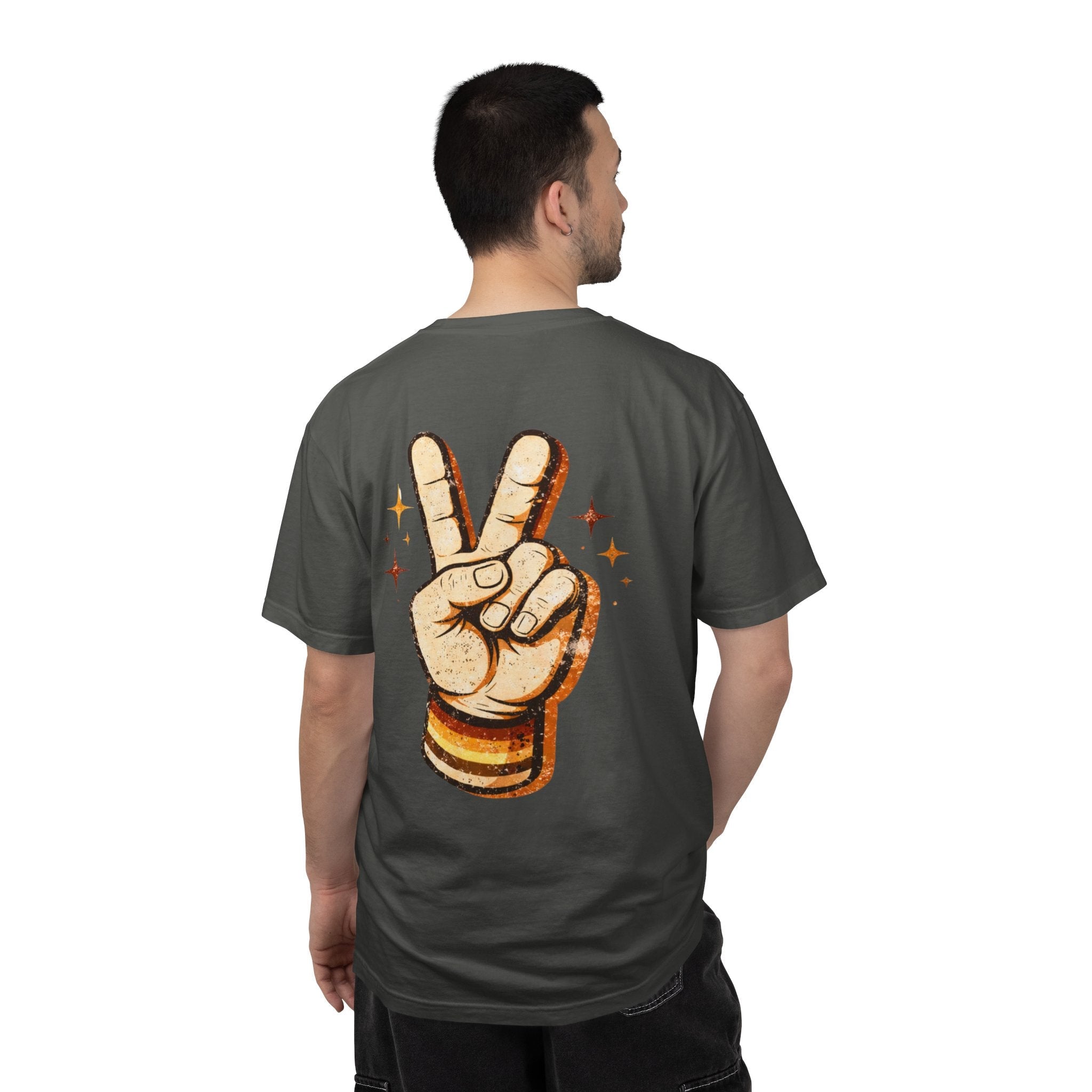 Man wearing a dark gray t-shirt with a peace sign design on the back, standing against a white background.
