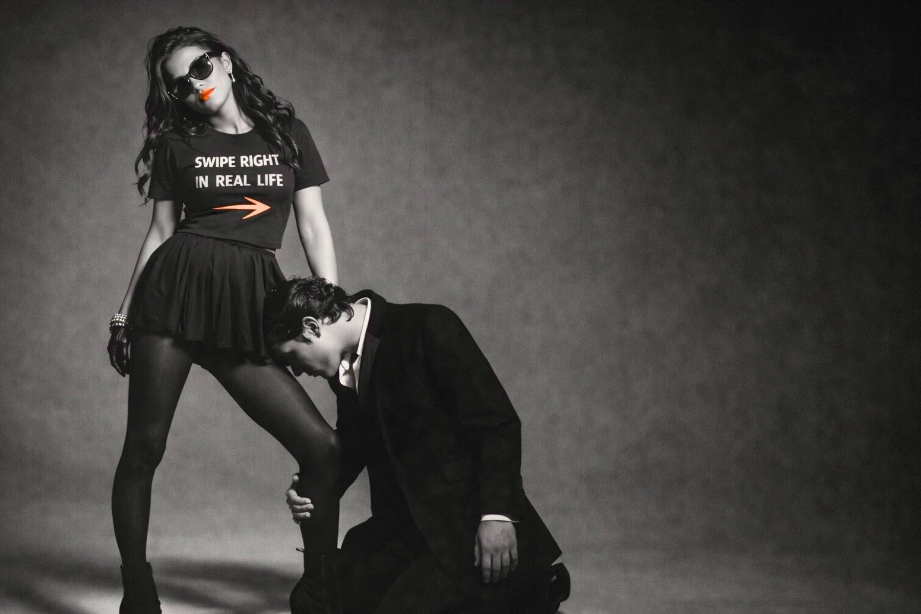 Woman wearing a 'Swipe Right in Real Life' shirt with a man kneeling beside her in black and white studio setting by Relatable Designs