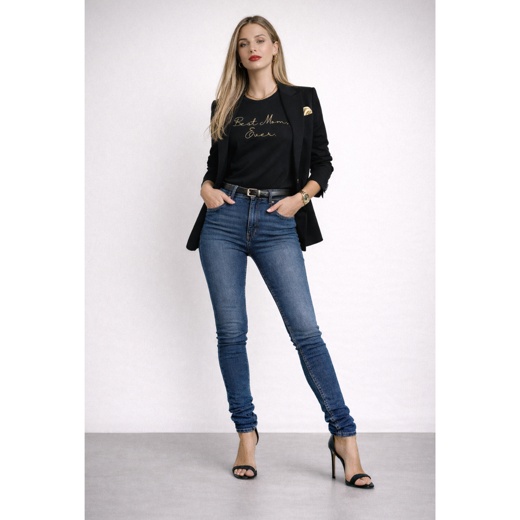 Woman wearing a black blazer with text, blue jeans, and high heels on a white background