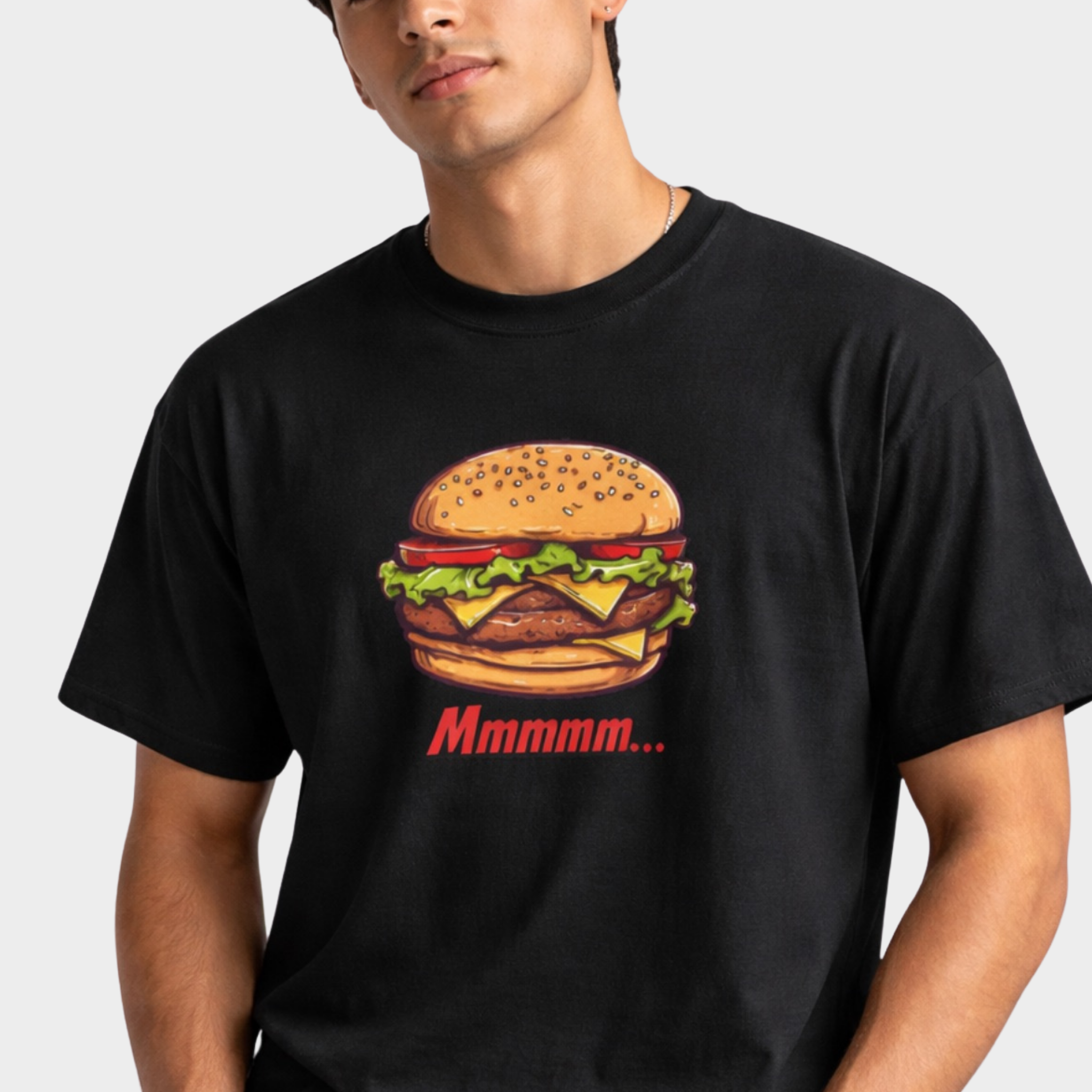 Man wearing a black t-shirt with a colorful burger graphic and 'Mmmmm...' text by Relatable Designs