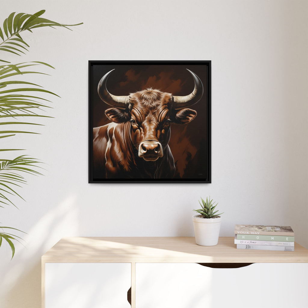 Framed rustic artwork of a bull on a wall above a desk with a plant and books.