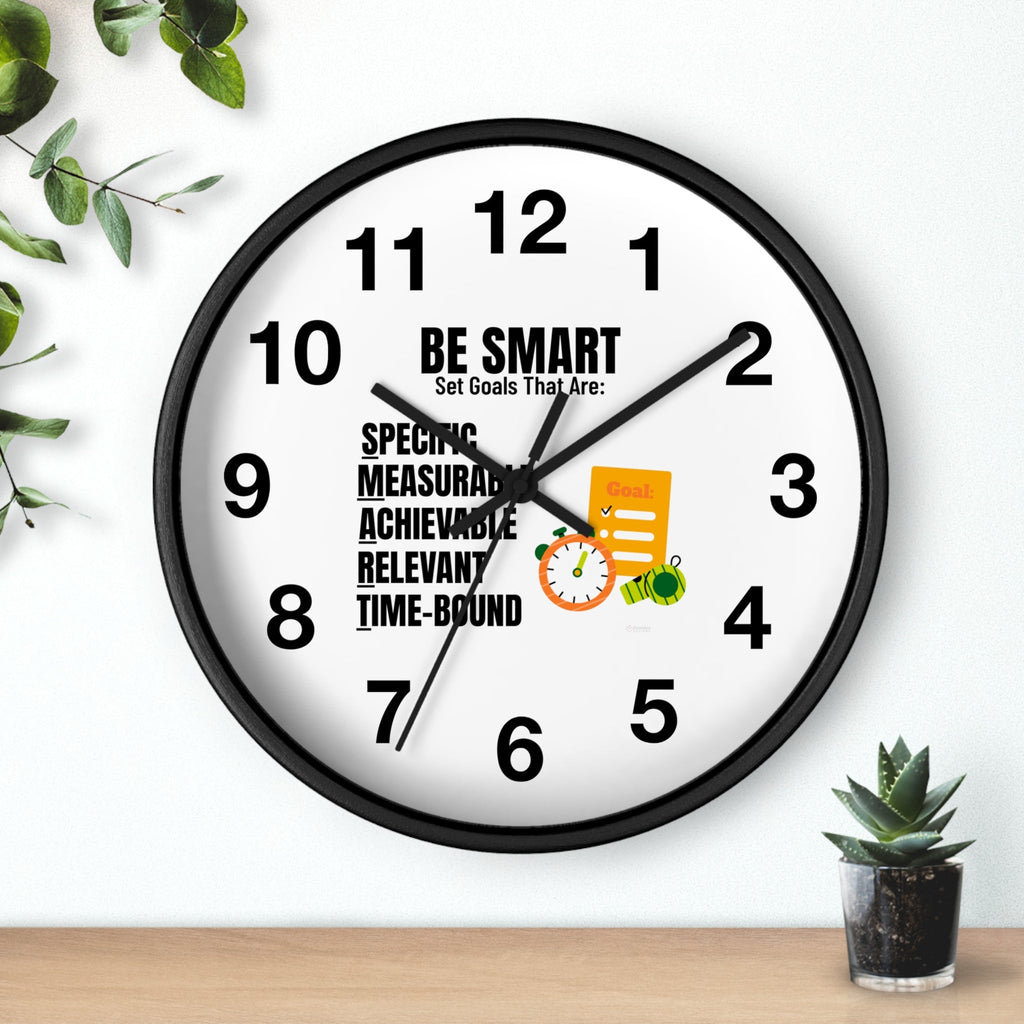 Wall clock with motivational quote on a white wall with plants.