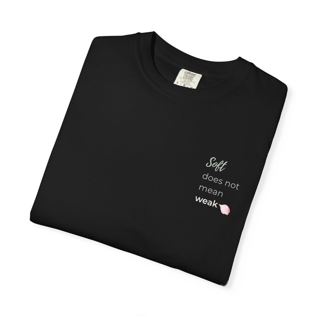 Folded black tee with text Soft Does Not Mean Weak.