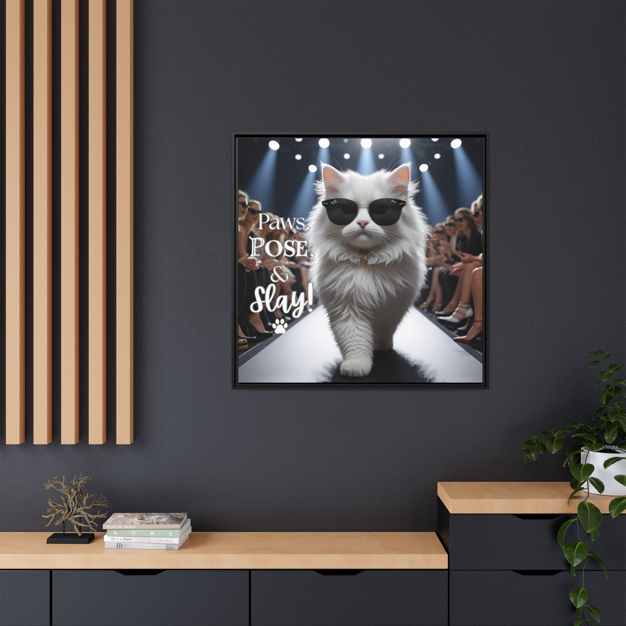 Framed canvas print of a cat wearing sunglasses with text on a dark wall with wooden shelves.
