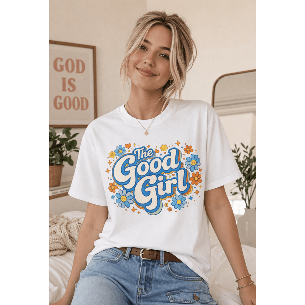 Woman wearing a white t-shirt with 'The Good Girl' design in a casual home setting.