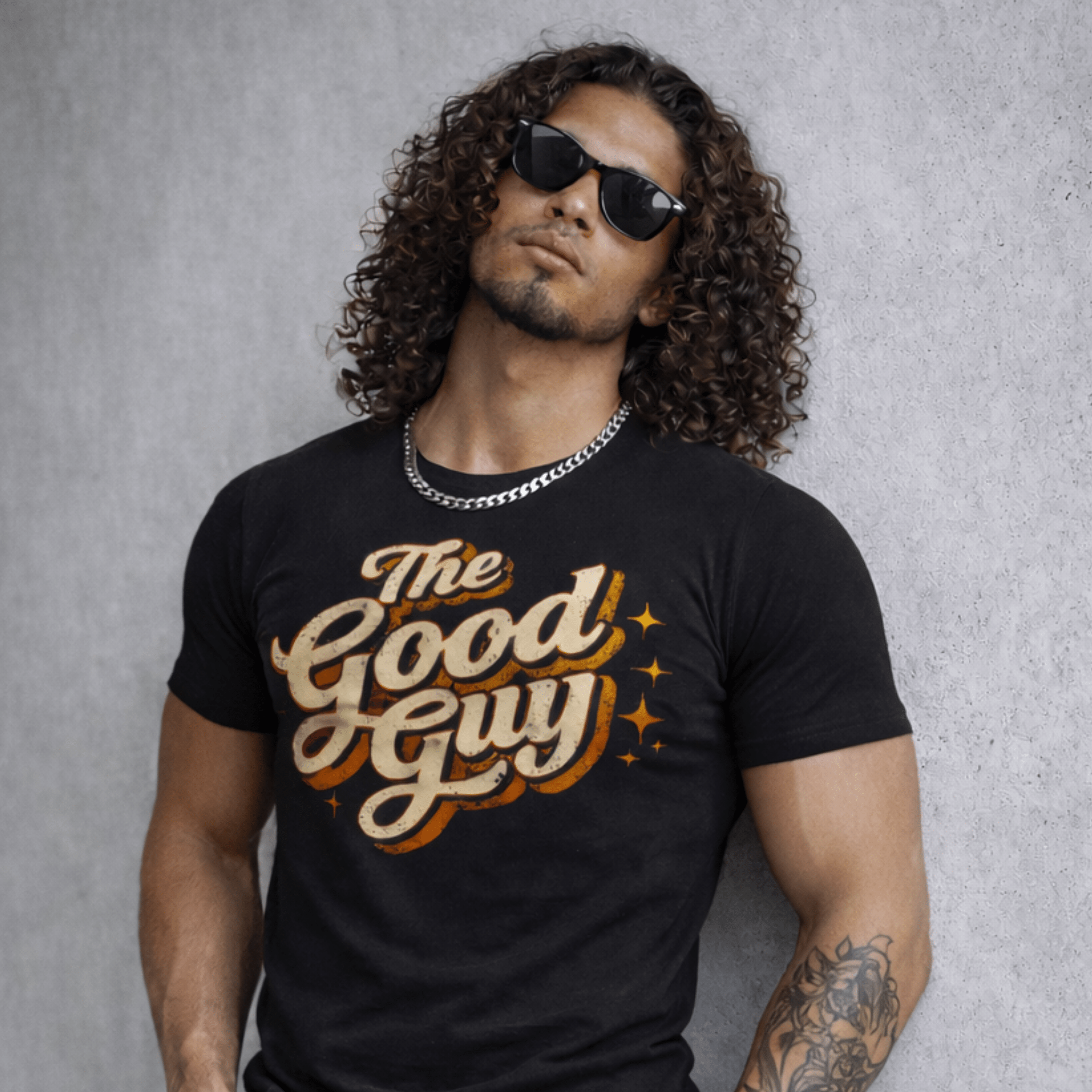Man wearing a black t-shirt with 'The Good Guy' text against a gray background by Relatable Designs