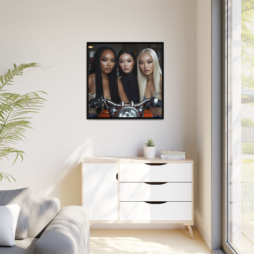 Framed artwork of three women standing by red motorcycle on a wall above a white cabinet with a plant and books.