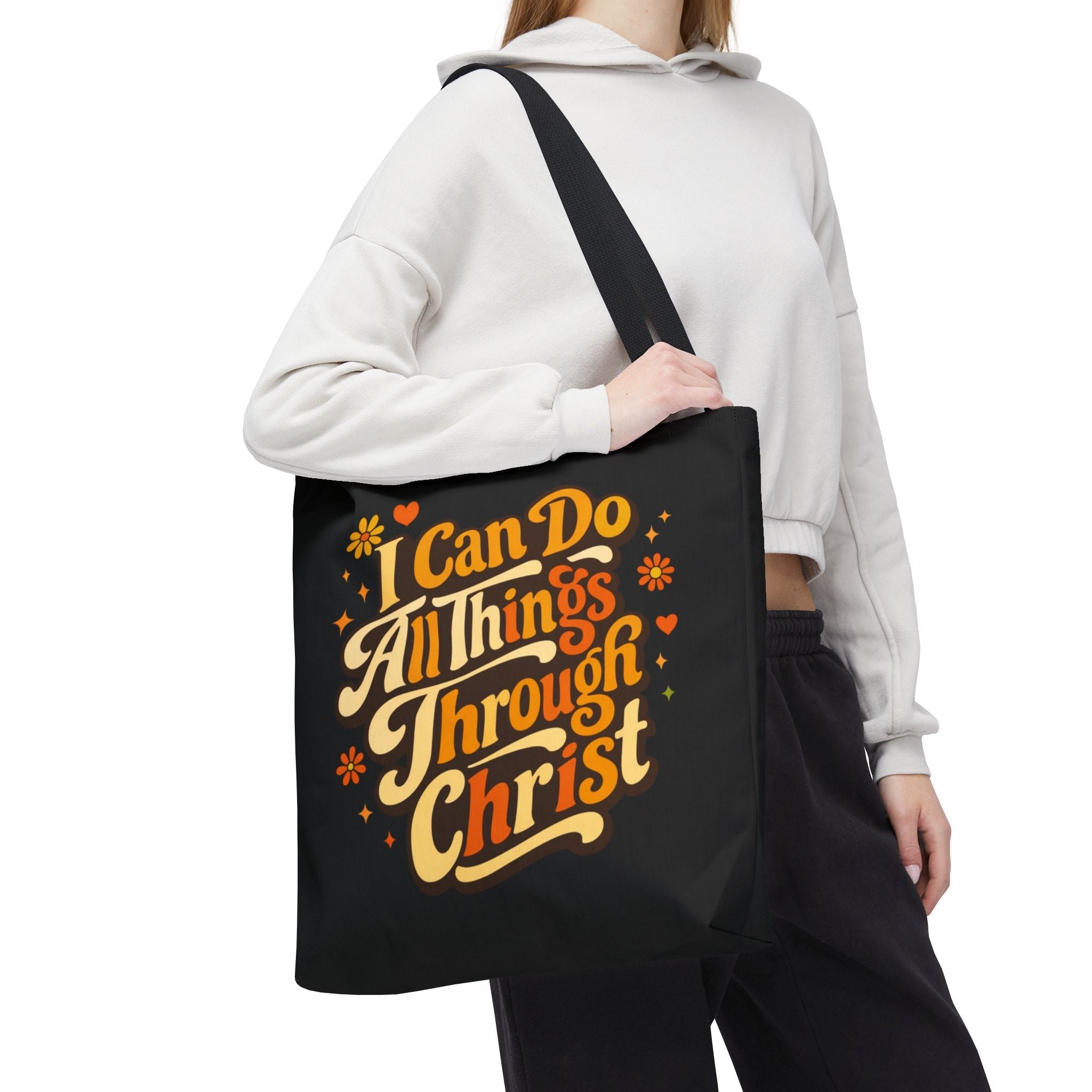 Person holding a black tote bag with motivational text design - 'I Can Do All Things Through Christ'