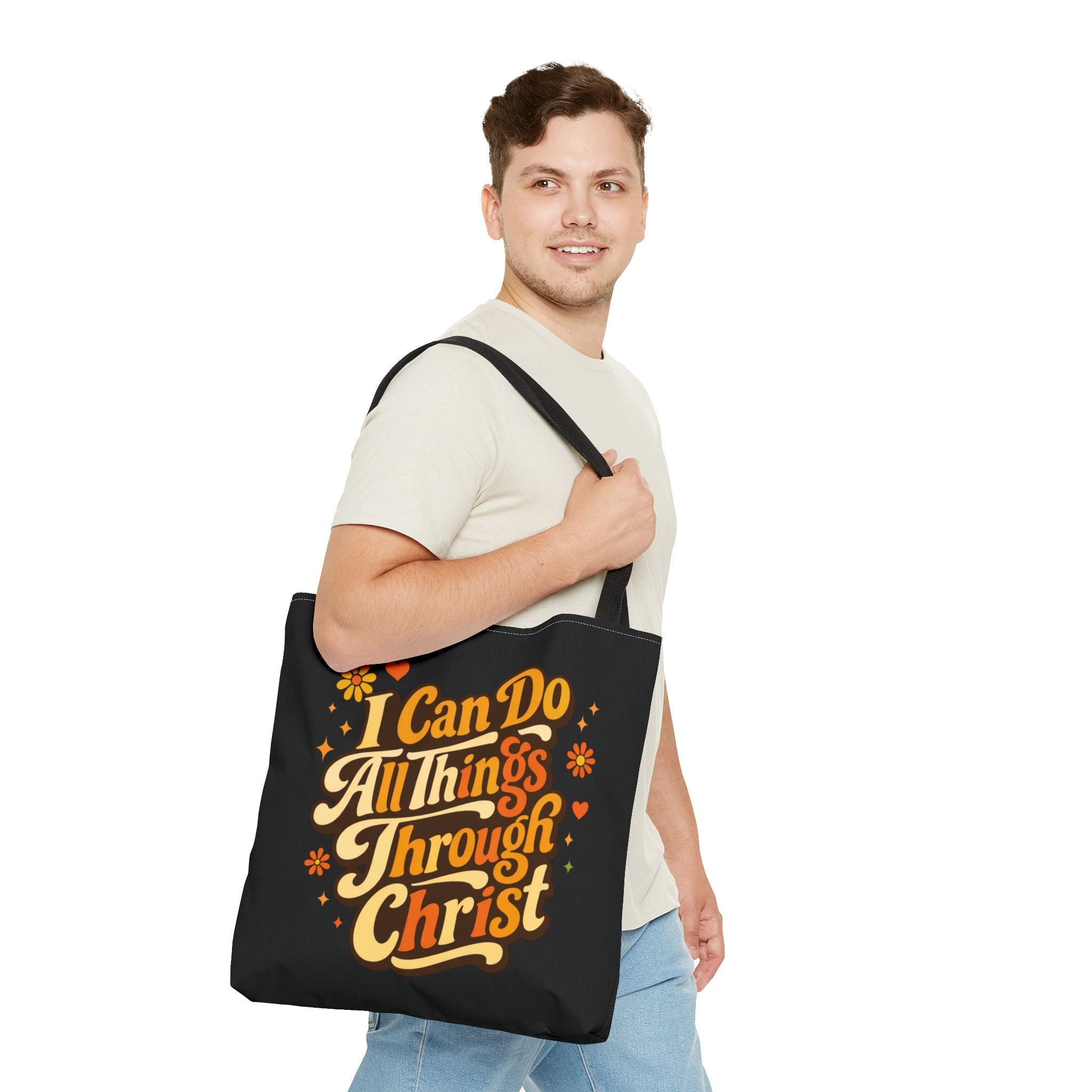 Man carrying a black tote bag with motivational quote 'I Can Do All Things Through Christ' on a white background