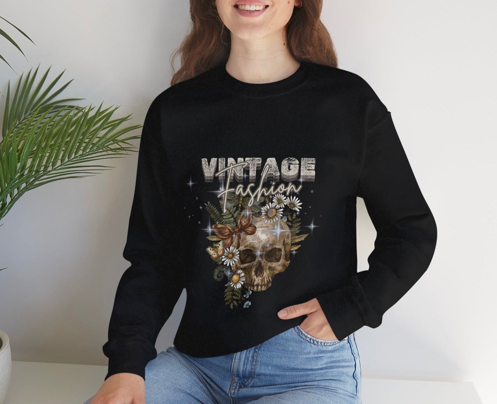 Person wearing black sweatshirt with 'Vintage Fashion' design, sitting against a white wall with a plant by Relatable Designs.
